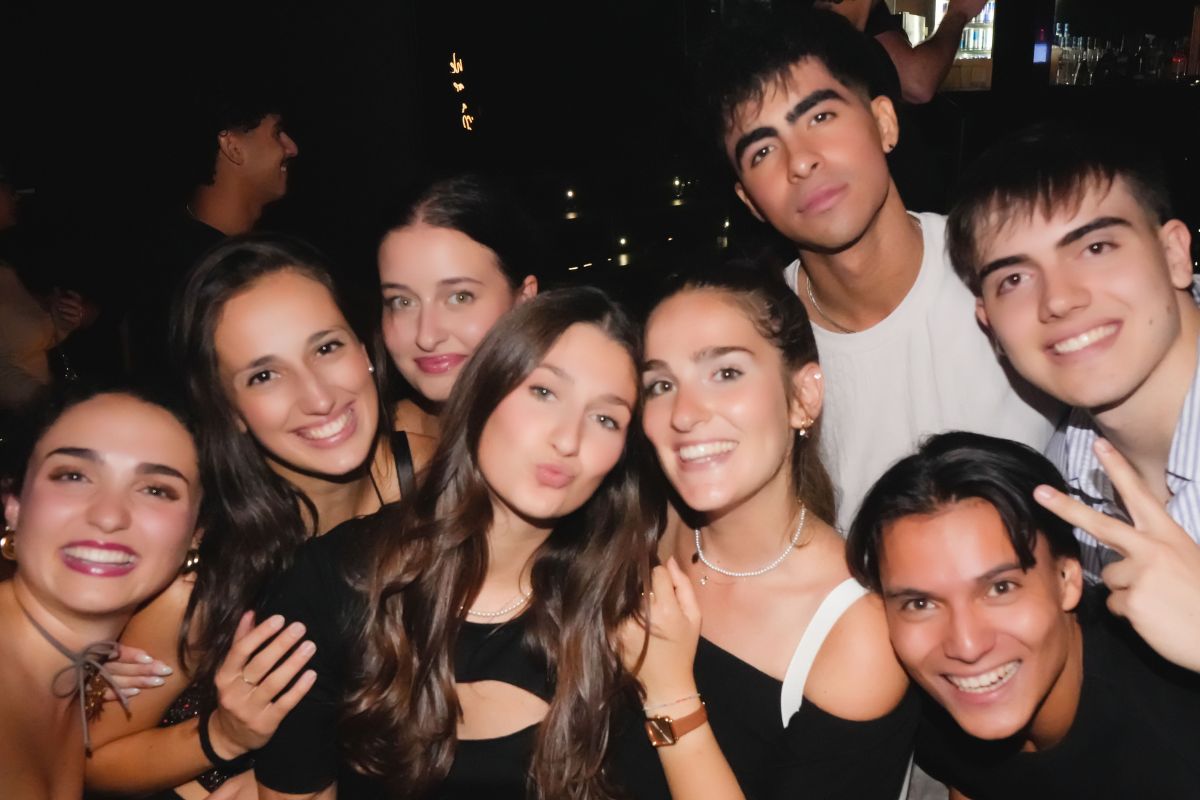 Paris pub crawl group enjoying nightlife in a crowded club with drinks