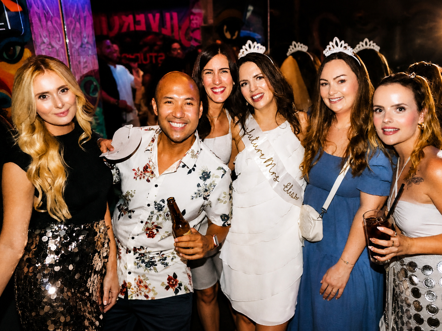 Hen party group posing with drinks during a Pub Crawl Paris club stop