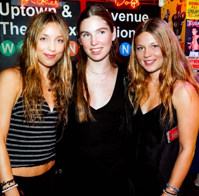 Erasmus friends posing in a neon-lit bar during a Paris nightlife experience